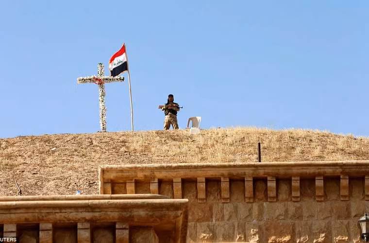 Một người lính đứng trên nóc nhà thờ ở làng Qaraqosh sau giải phóng.