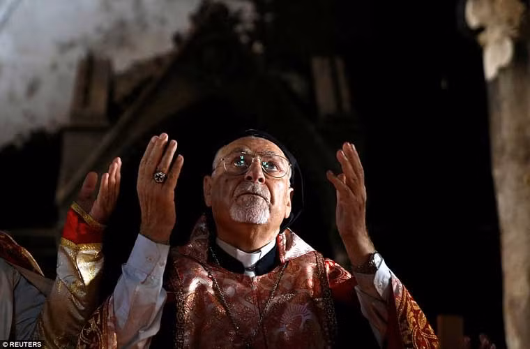 Một linh mục đang cử hành nghi lễ cầu nguyện ở thị trấn Qaraqosh gần Mosul. Đây là lần đầu tiên người dân và các linh mục ở làng này làm lễ cầu nguyện vào ngày Chủ nhật kể từ khi IS xâm chiếm nơi này.