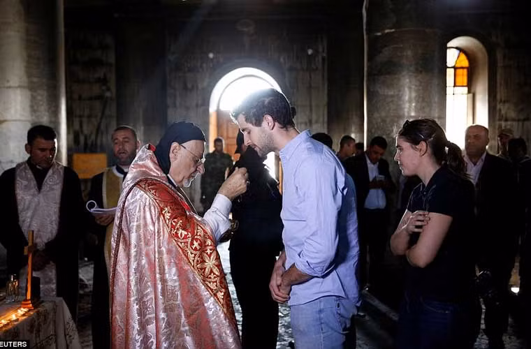 Hôm 30/10, những người dân sống ở thị trấn Qaraqosh (vốn chủ yếu là những người theo đạo Cơ đốc giáo) đã tới nhà thờ để làm lễ cầu nguyện bất chấp các cuộc giao tranh vẫn diễn ra khi chiến dịch giải phóng Mosul từ tay phiến quân IS bước sang tuần thứ 3. Ảnh: Linh mục ở nhà thờ Grand Immaculate Church đang làm lễ cho các tín đồ.