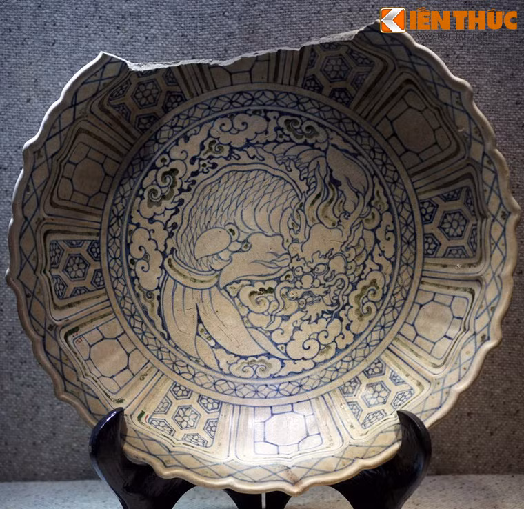 Hình cá hóa rồng trên đĩa gốm nhiều màu thời Lê sơ, thế kỷ 15. Hiện vật tàu cổ Cù Lao Chàm, Hội An, Quảng Nam. Cá hóa rồng vốn là truyền thuyết được lưu truyền phổ biến ở Việt Nam, gắn với tích "Ngư dược Vũ môn" của Nho học, tượng trưng cho sự kiên trì, bền chí chinh phục tri thức để tiến tới thành công của sĩ tử. Trong nghệ thuật Việt, đề tài cá hóa rồng bắt đầu xuất hiện từ thời Trần (thế kỷ 13 - 14), phổ biến và đạt đến đỉnh cao thời Lê sơ (thế kỷ 15).