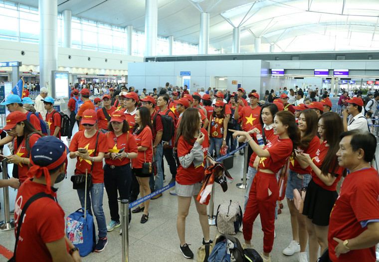 Hàng trăm người hâm mộ mặc áo cờ đỏ sao vàng làm thủ tục bay sang Philippines để cổ vũ cho đội tuyển Việt Nam đá với đội chủ nhà.