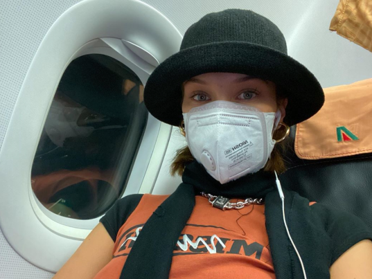 Bella Hadid chọn khẩu trang chống độc để phòng lây nhiễm Covid-19 khi đi máy bay.