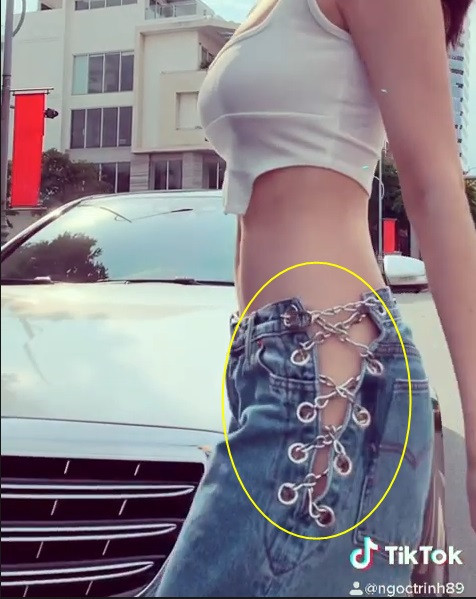 Đáng chú ý là chiếc quần jean thụng mà Ngọc Trinh mặc cùng áo crop-top khiến dân tình thực sự “nóng mặt”. Thiết kế đan dây hai bên hông để lộ người đẹp quê Trà Vinh mặc quần không nội y.