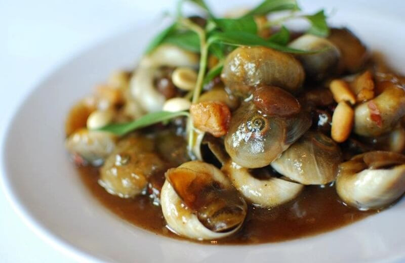 Đun một nồi nước sôi, thêm vào 15gr gừng cắt lát đập dập, cho ốc vào trụng sơ 2 phút sau đó vớt ra rửa sạch. Đun chảy bơ lạt, cho tỏi, hành tím, sả, ớt vào phi thơm. Thêm 150ml nước cốt me vào đun sôi. Nêm 3 muỗng canh đường trắng, 2 muỗng canh nước mắm, khuấy cho tan đường. Nếm lại sốt me cho vừa ăn.