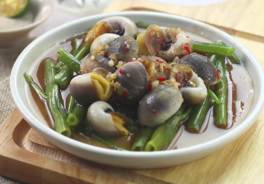 Tiếp theo cho 150gr rau muống đã nhặt sạch lá, trút ốc mỡ vào, xào tiếp 2 phút cho ốc mỡ thấm gia vị và rau muống chín rồi nhắc xuống. Bạn không thích nước nước khi xào chung với rau muống thì thay thế băng rau răm thì nước xốt sệt và đậm đà hơn.