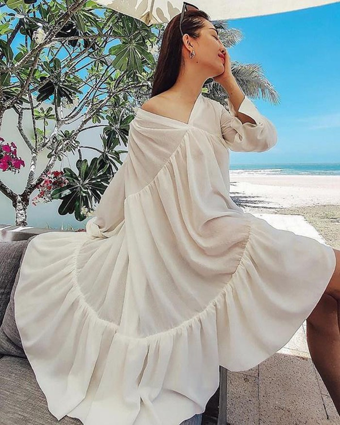 Á hậu Lệ Hằng cũng diện váy nữ tính và thư giãn ở nơi có biển, nắng vàng.