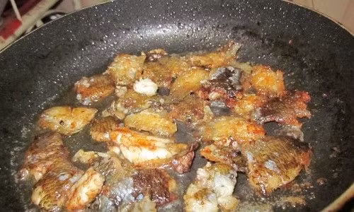 Đợi thịt cá ngấm gia vị rồi cho cá vào chảo mỡ nóng già để chiên vàng.