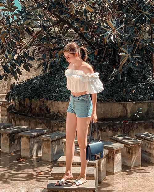 Cách mix áo trễ vai trang trí bèo nhún đi kèm quần short jeans của á hậu Huyền My trông rất trẻ trung và mát mẻ giữa ngày hè.