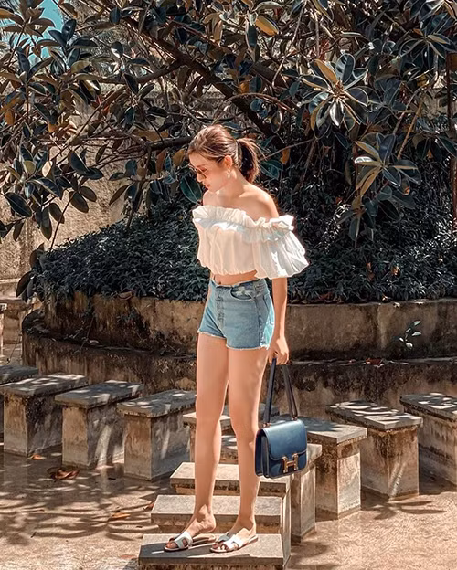 Cách mix áo trễ vai trang trí bèo nhún đi kèm quần short jeans của á hậu Huyền My trông rất trẻ trung và mát mẻ giữa ngày hè.