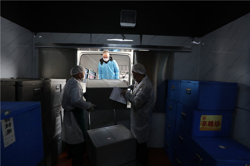 Các hộp đồ ăn được vận chuyển lên xe giao hàng cẩn thận.