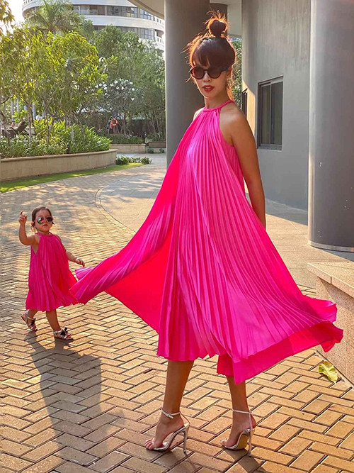 Mẹ con Hà Anh cùng diện váy cổ yếm gam hồng neon khi đi biển. 