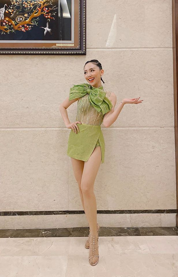 Chiếc đầm xanh với phần trên thiết kế xuyên thấu và nhấn nơ ở ngực tạo sự gợi cảm pha nét trẻ trung, nữ tính cho nữ ca sĩ.