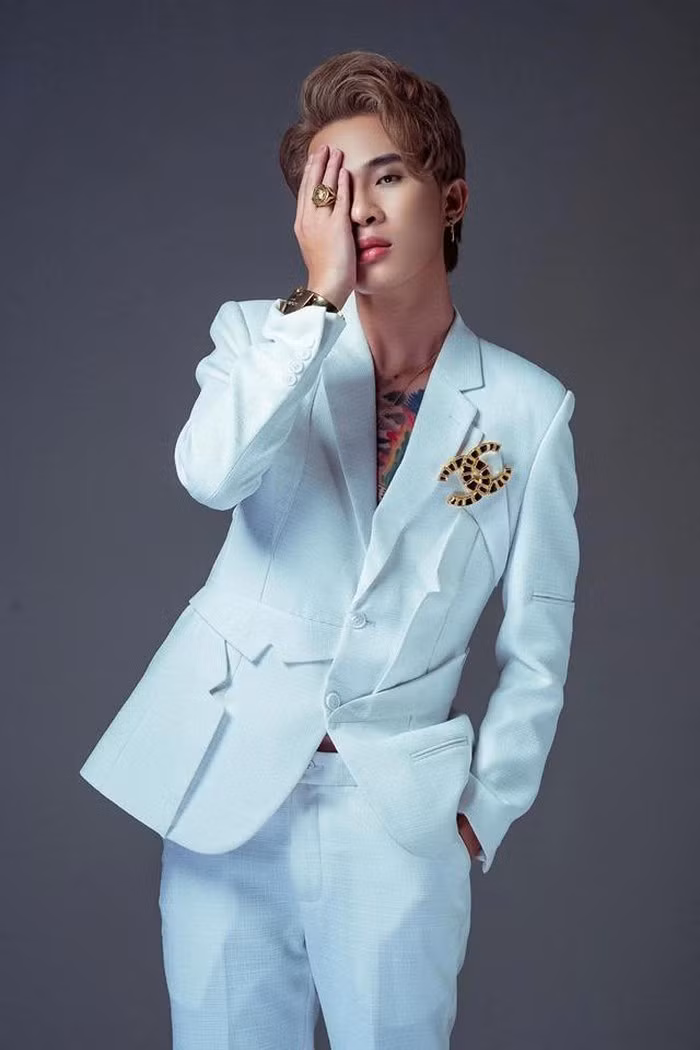 Nam ca sĩ diện bộ suit trắng khá bảnh bao nhưng lại làm lộ hình xăm ngực thiếu tinh tế.