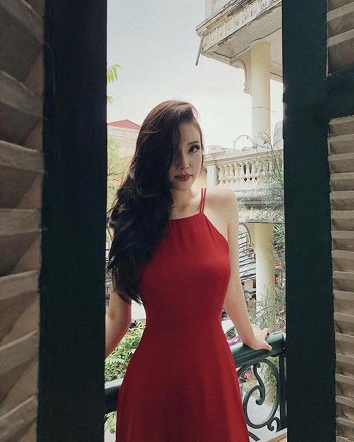 Ngọc Phượng diện váy đỏ cổ yếm với mái tóc gợn sóng buông sang một bên đầy quyến rũ.