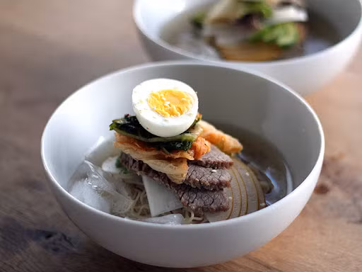 Vị thanh ngọt, mát lành từ những sợi mì đã được ướp đá, độ dai hoàn hảo của chúng cùng phần nước dùng chua chua của kim chi, ngọt ngọt của nước thịt bỗng chốc khiến cái nóng của mùa hè tan đi mất.