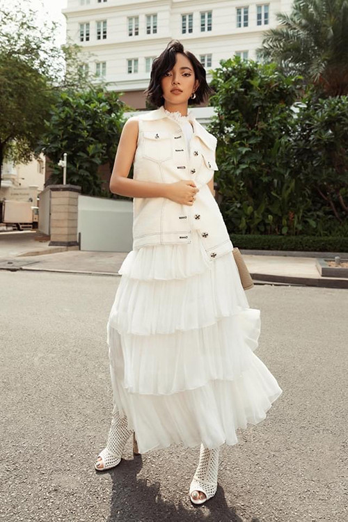 Châu Bùi sử dụng giày lưới hợp xu hướng xuân hè 2020 để tạo điểm nhấn cho set trang phục gồm váy xếp tầng và áo jacket dáng sát nách.