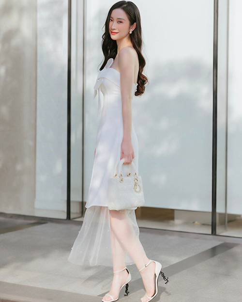 Jun Vũ khoe vẻ đẹp mong manh khi xuống phố với set đồ tiệp sắc trắng mix cùng túi Dior, giày cao gót cùng tông.