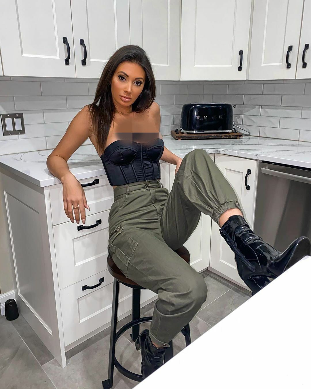 Chiếc áo cúp ngực kiểu corset phô trương vòng một đầy đặn của cô.