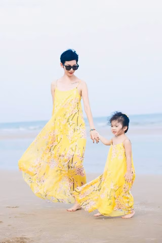 Bé Thỏ mặc váy đôi màu vàng nổi bật với mẹ trong chuyến đi biển.