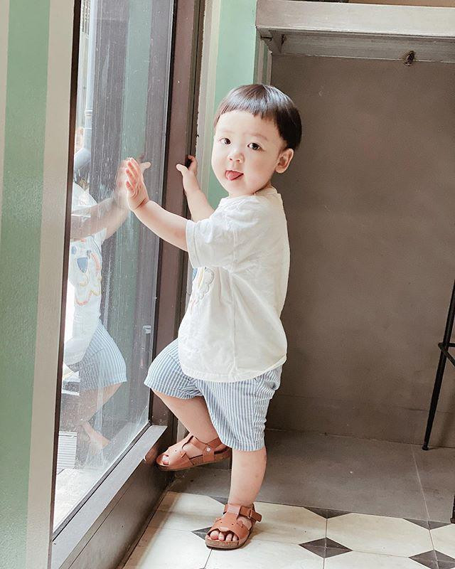 Cậu bé gần hai tuổi mặc áo thun cùng quần short để thoái mái chạy nhảy.