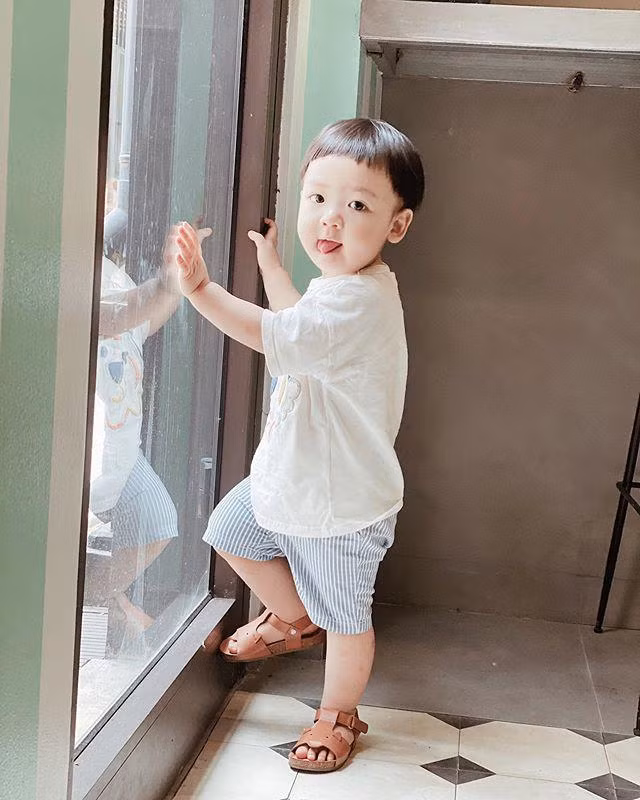 Cậu bé gần hai tuổi mặc áo thun cùng quần short để thoái mái chạy nhảy.