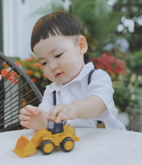 Bé Kem được mẹ diện cho chiếc sơ mi trắng trông chững chạc hẳn ra.