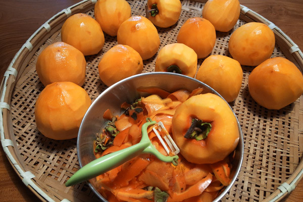 Sau đó thì bạn lấy chỉ buộc cuống trái hồng lại với nhau. Bạn chuẩn bị một nồi nước có pha sẵn rượu trắng vào và đun sôi, sau đó thì cho hồng vào ngâm khoảng 2 đến 3 phút để khử trùng bề mặt trái hồng để cho hồng không bị hỏng.