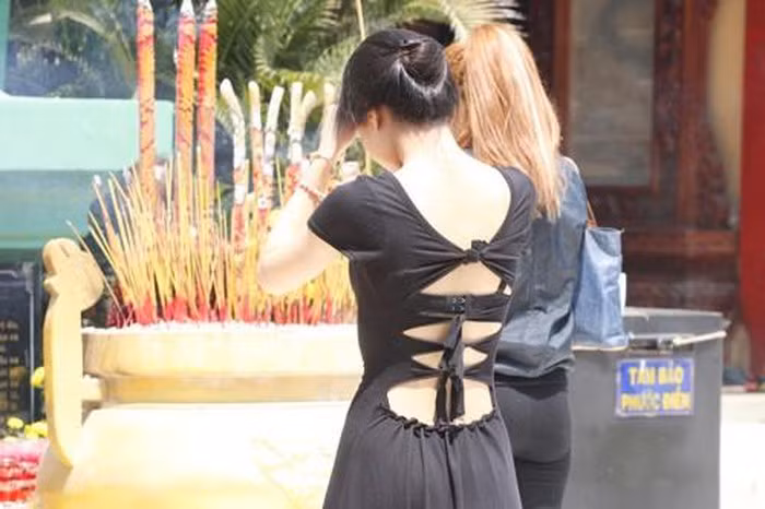 Cách ăn mặc hớ hênh làm mất đi sự tôn nghiêm, thanh tịnh nơi cửa phật. Ảnh: Vietnammoi.