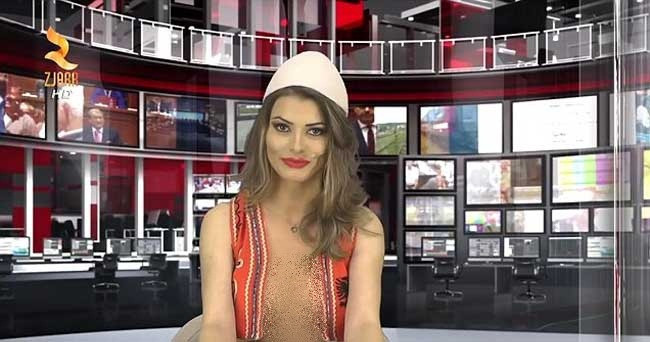 Greta Hoxa cũng mặc mốt "thả rông" như đồng nghiệp cũ, kể cả với áo bình thường hay ghi lê Albania truyền thống trong khi đưa tin trong lễ kỷ niệm Ngày giải phóng.