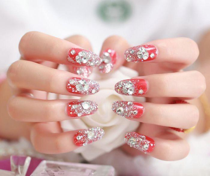 Những mẫu móng đính đá sắc đỏ rực rỡ thế này được nhiều chị em khá ưa chuộng để diện chơi Tết.