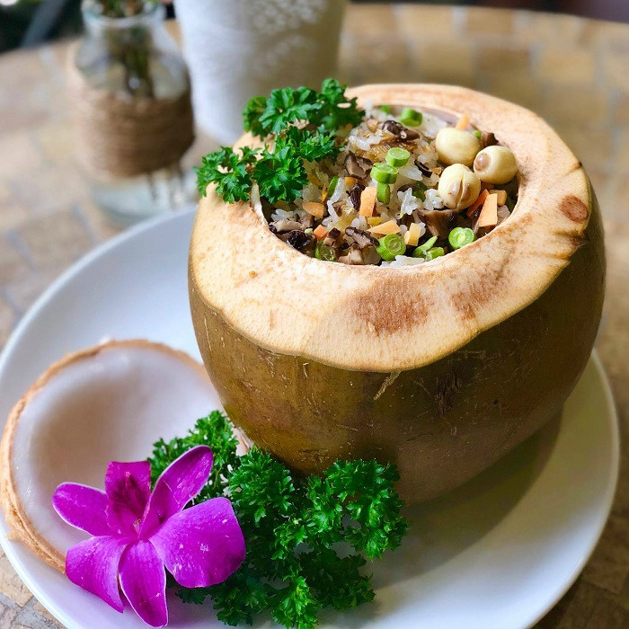 Khi trái dừa đã được lấy hết nước, cho gạo vào sao cho đến lúc cơm chín nở đầy là vừa. Tiếp theo rót nước dừa xăm xắp mặt gạo. Cho dừa vào nồi, hấp cách thủy khoảng một giờ là được.