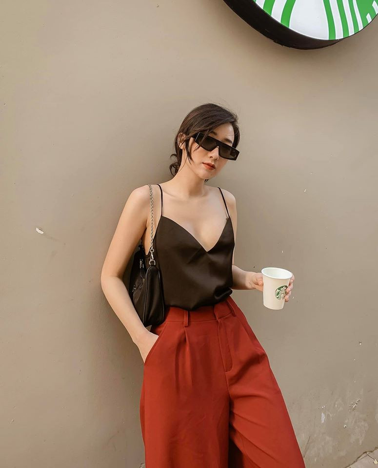 Áo hai dây đen trễ nải phối cùng quần ống rộng đỏ tạo nét sang chảnh, quyến rũ cho người đẹp Hà thành khi xuống phố.