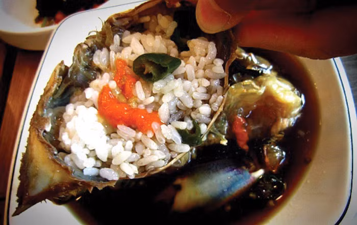 Món ăn được dùng kèm cùng cơm trắng. Người Hàn có thói quen trộn cơm trắng vào mai cua để hòa quyện với phần gạch đỏ, rồi mới thưởng thức.