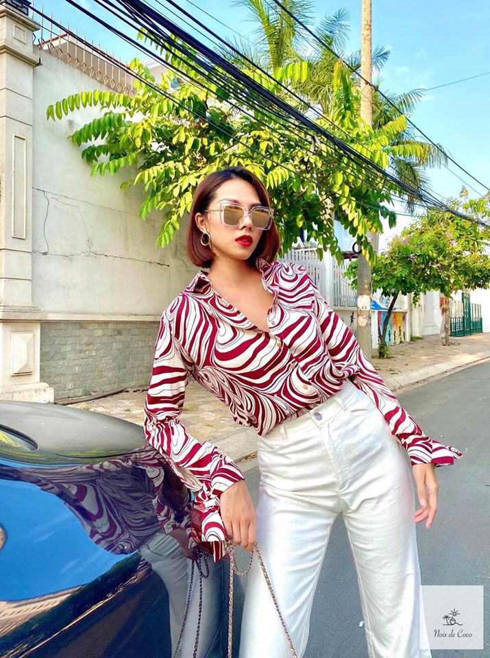 Người mẫu Minh Triệu ăn mặc sang chảnh với áo sơ mi họa tiết đỏ trắng và quần trắng nổi bật.