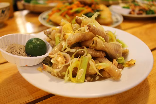 Nấu nước sôi, luộc chân gà với gừng và 1/2 sả đập dập. Khi chân gà chín tới, vớt ra cho vào nước đá lạnh cho nguội, vớt ra. Cho chân gà vào ngăn mát tủ lạnh khoảng 20 phút để có độ giòn. Pha nước ngâm chân gà theo công thức: 3 muỗng canh giấm, 3 muỗng canh nước mắm, 300 ml nước lọc, 3 muỗng canh đường. Khuấy tan hỗn hợp rồi đun sôi rồi cho sả, ớt, tắc và lá chanh xắt nhuyễn vào. Nước sôi một lần nữa thì tắt bếp.