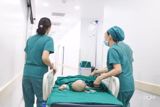 Các bác sĩ đẩy giường của 2 bé vào phòng phẫu thuật. Ảnh: VTV Digital.