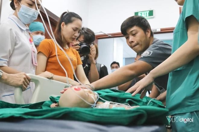 Bố mẹ của Trúc Nhi - Diệu Nhi quyến luyến đi theo hai con cho tới cửa phòng phẫu thuật. Ảnh: VTV Digital.