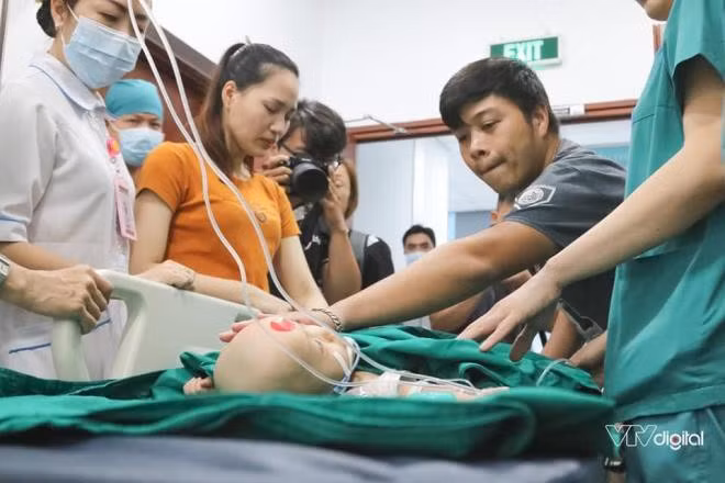 Bố mẹ của Trúc Nhi - Diệu Nhi quyến luyến đi theo hai con cho tới cửa phòng phẫu thuật. Ảnh: VTV Digital.