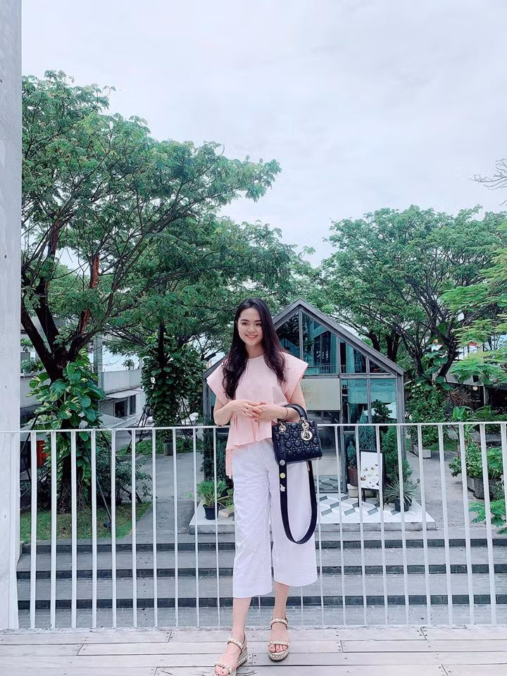 Quỳnh Anh khá chuộng những trang phục có màu sắc nhẹ nhàng. Dù ăn mặc đơn giản nhưng tay xách túi Dior làm tăng lên mức sành điệu của cô nàng.