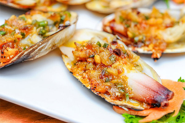 Tu hài sốt chua cay. Tu hài sau khi mua về, ngâm trong nước vo gạo để bớt vị mặn cũng như nhả hết bùn, đất, sau đó ngâm qua nước sôi hơi ấm để vỏ tu hài bớt vị mặn. Vớt ra rửa sạch lại và bắt đầu chế biến.