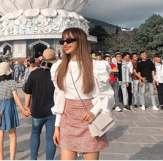 Nhã Ca trông cực thời thượng khi kết hợp áo sơ mi trắng cách điệu phần tay phồng với chân váy ngắn