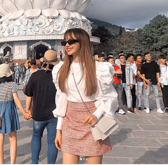 Nhã Ca trông cực thời thượng khi kết hợp áo sơ mi trắng cách điệu phần tay phồng với chân váy ngắn