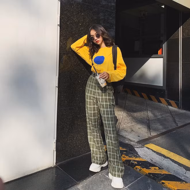 Áo thun vàng phối với quần kẻ karo tạo nên nét cá tính cho nàng hot girl sinh năm 2000.