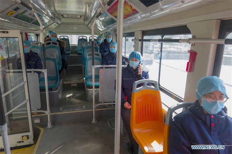 Các bác sĩ Bệnh viện Liên kết Đại học Qingdao tới Hồ Bắc sau khi chữa trị cho các bệnh nhân nhiễm COVID-19 ngồi cách xa nhau trên xe buýt nhằm tránh lây nhiễm chéo khi họ trở về khách sạn trong giờ nghỉ ở Vũ Hán ngày 20/2.
