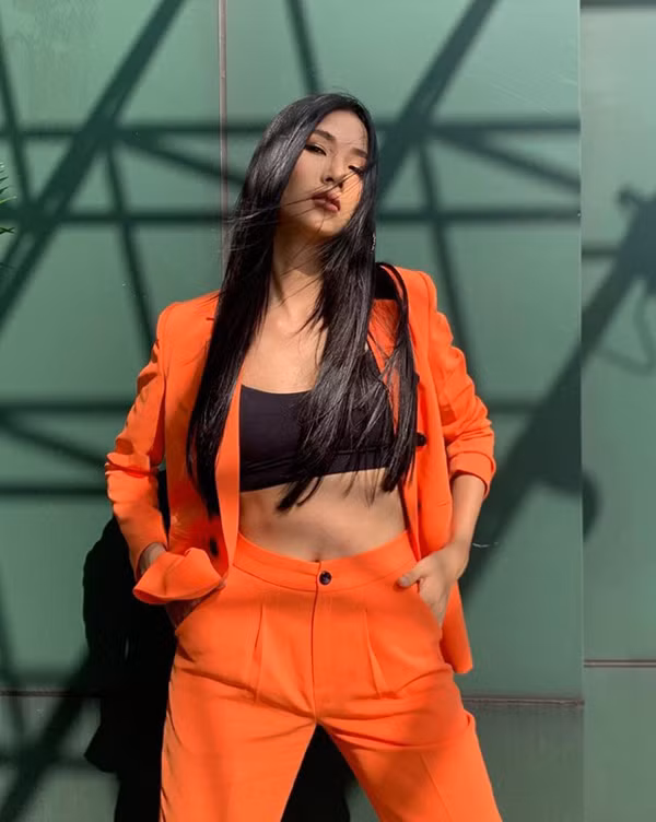 Hoàng Thùy chọn bộ suit tông cam nổi bật cho trang phục dạo phố.