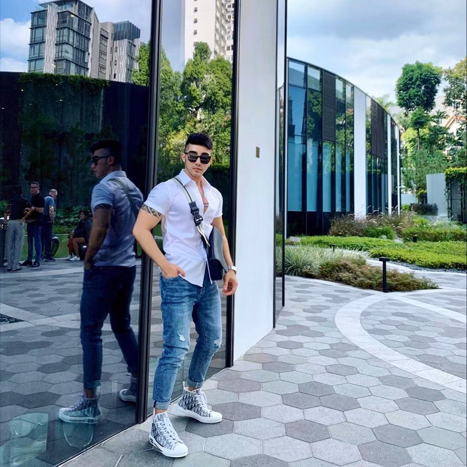 Anh phối áo sơ mi trắng với quần jeans rách gối năng động xuống phố.