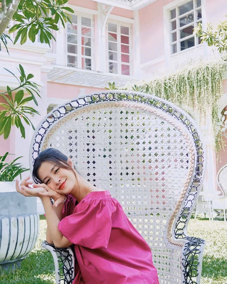 Bà bầu diện váy hồng cánh sen đậm chất nữ tính được trang trí hàng cúc to bản và tay bồng theo phong cách cổ điển.