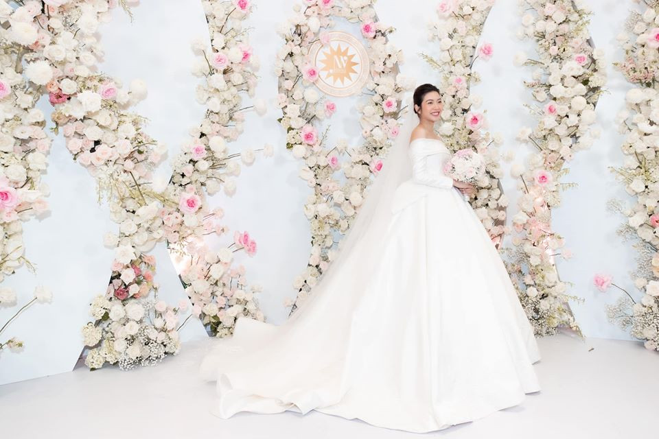 NTK đã sử dụng chất liệu nhập khẩu cao cấp là Satin Duchesse thượng hạng, có màu ánh nhũ Champagne, kết hợp ren Guipure được dệt từ sợi tơ thượng hạng. Để nhấn điểm cho các họa tiết, 2.000 viên đá Swarovski đã được đính chìm trên ren, tạo nên sự lấp lánh, nổi bật mà không hề nặng nề khi mặc.