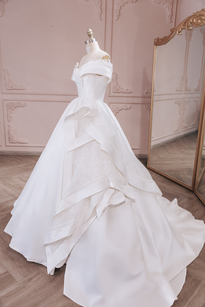 Để mô tả được đúng tên của nàng, NTK tạo điểm nhấn khối 3D bằng việc sử dụng các lớp vải lụa Organza pha ren Chantilly và sắp xếp khéo léo để chúng có được độ bồng bềnh tự nhiên, khắc họa được đúng tên cô dâu nhất.