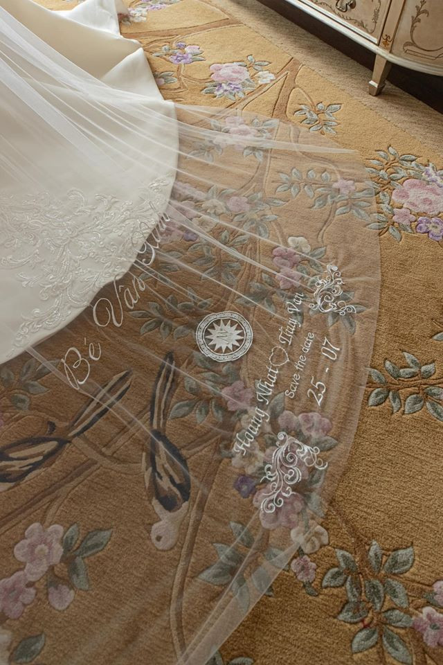 Đặc biệt, phần đuôi váy cưới dài 3m được sử dụng loại voan siêu mỏng của Á hậu. Chi tiết “Bé Vân Xinh” là ý tưởng bí mật của ông xã Thúy Vân, khi anh làm việc riêng với NTK để mang đến cho vợ mình một niềm vui bất ngờ. Đi kèm đó là tên, ngày cưới và logo mang ý nghĩa “Chúng ta” của hai vợ chồng, khẳng định sự độc quyền và đánh dấu cho 1 ngày cực kỳ hạnh phúc của cặp đôi.